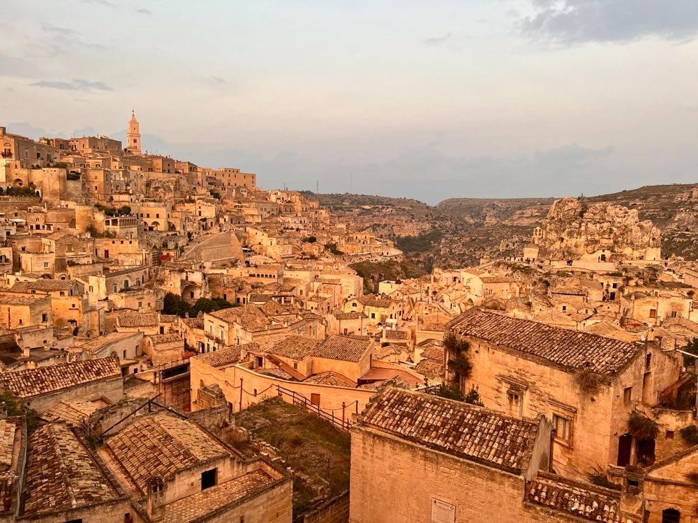 buildings lit up at sunset matera