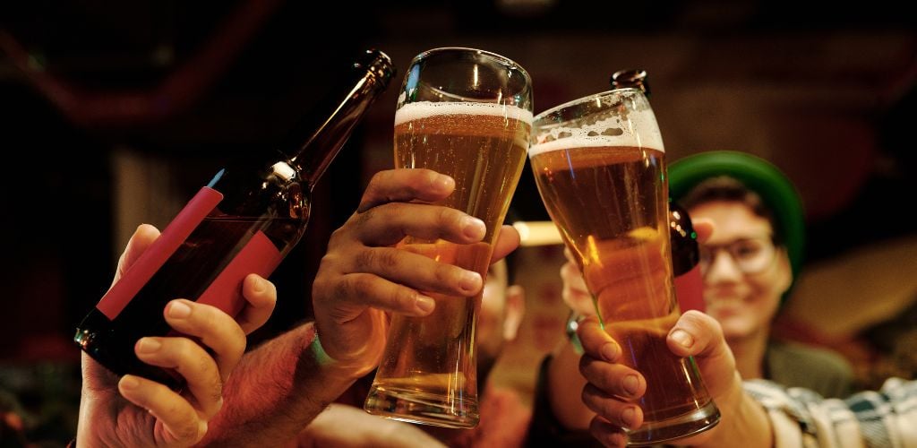 Friends drinking one bottle of beer and two glasses of beer.