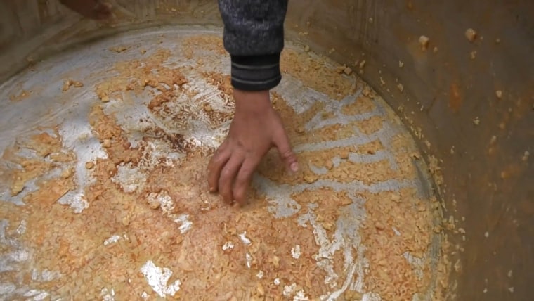 Child scrapes pot for food in Gaza.