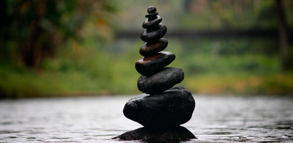 representation of balance in the form of stones balancing on top of one another in water