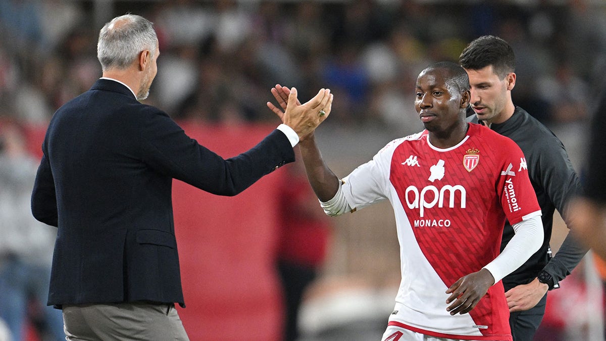 Mohamed Camara high fives his coach