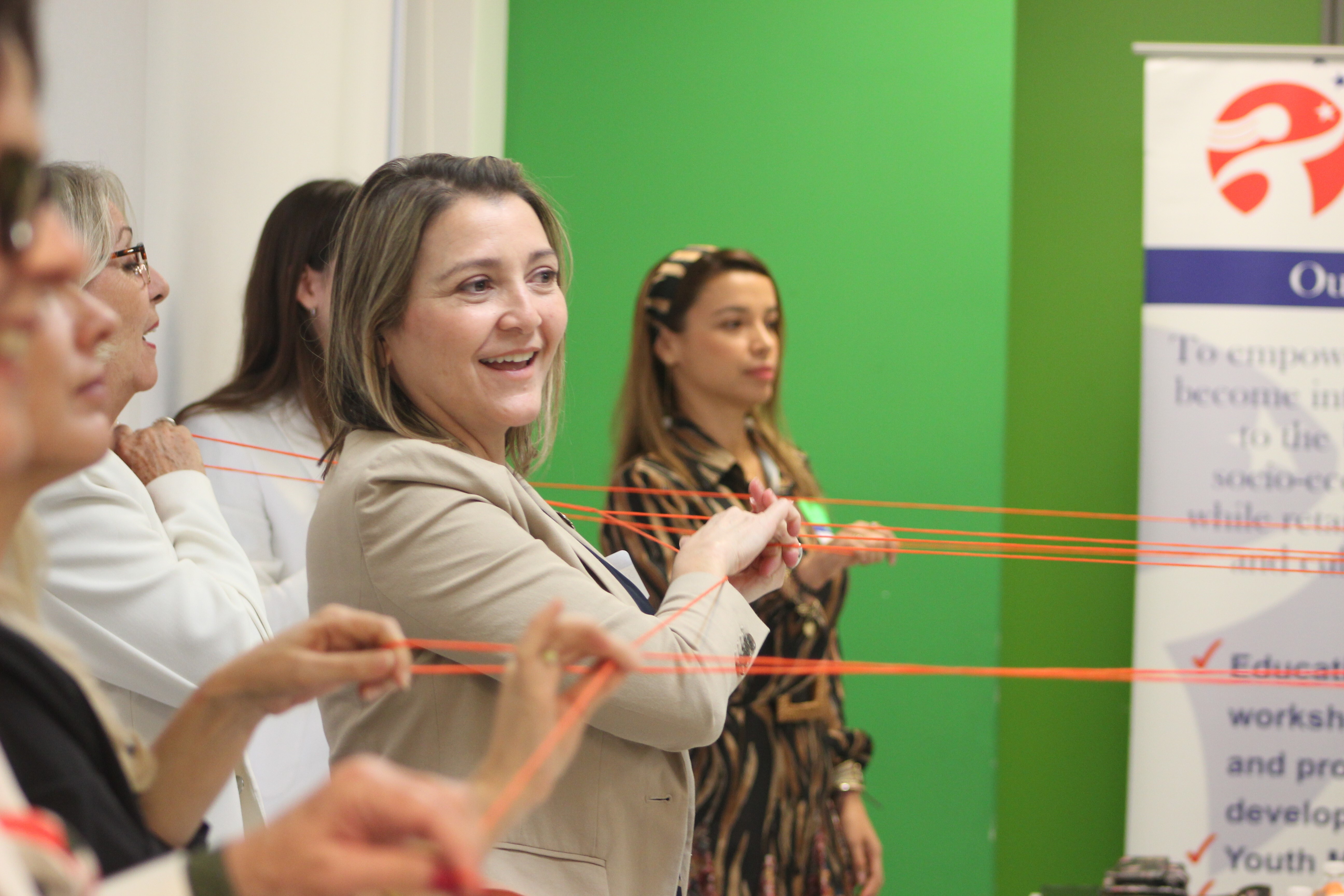 Scarlett Lanzas, second from right, and other information navigators do an exercise in which they use orange string to symbolize how communities are interconnected, at a Nov. 8, 2023, orientation for a pilot project on combating bad information.