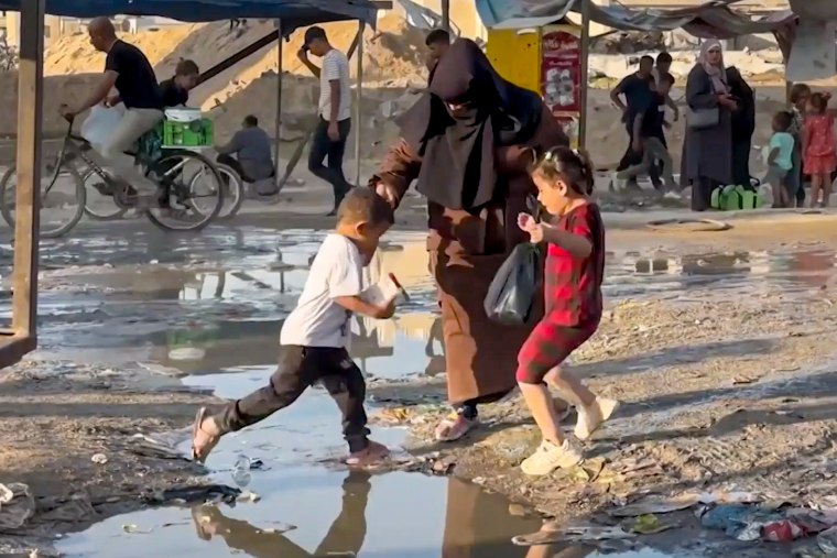 Kids walk across a pond in Gaza.