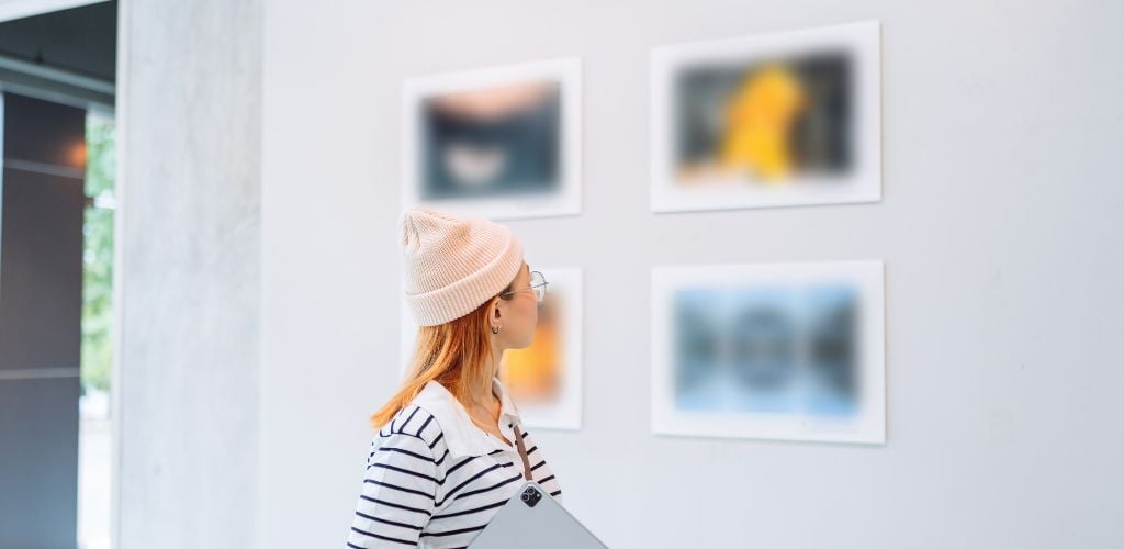 lady walking by admiring artwork on the walls in contemporary art museum 