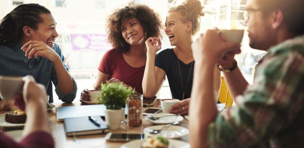 group of friends socialising over coffee in a cafe environment