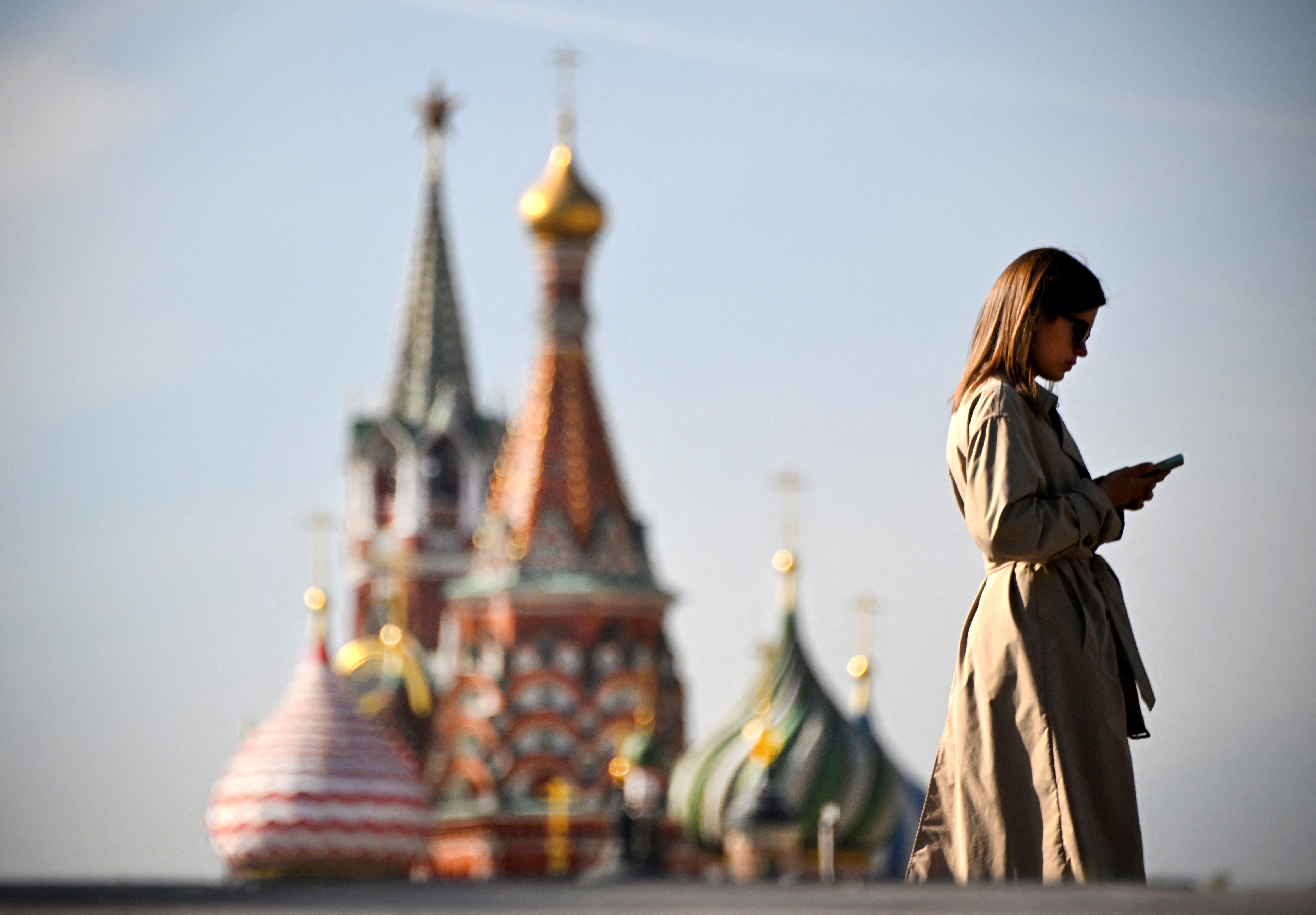 A woman walks in front of the Kremlin on September 23, 2024. U.S. intelligence officials say Russia has embraced artificial intelligence tools to try to sway American voters ahead of the November election. 