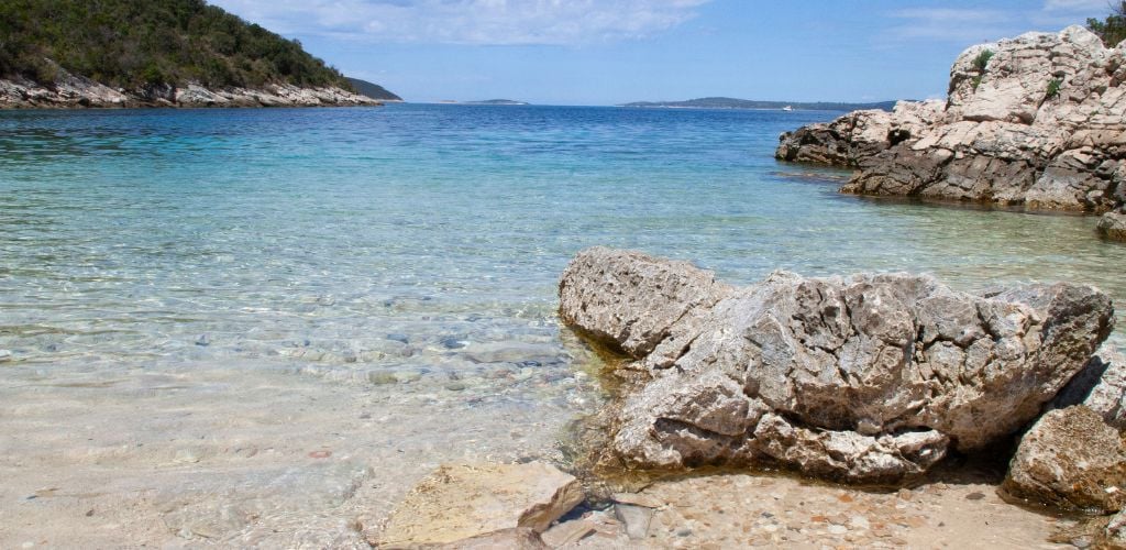 beach in Croatia, crystal clear waters and rocks in foreground