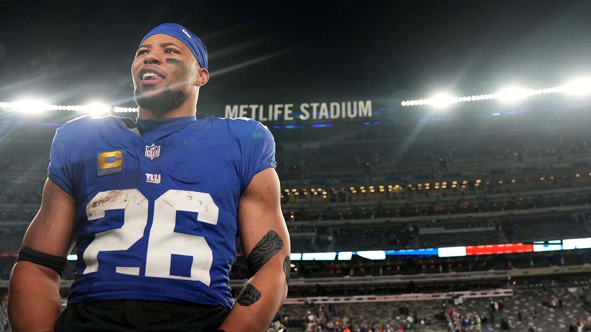 Saquon Barkley wears a Giants jersey 