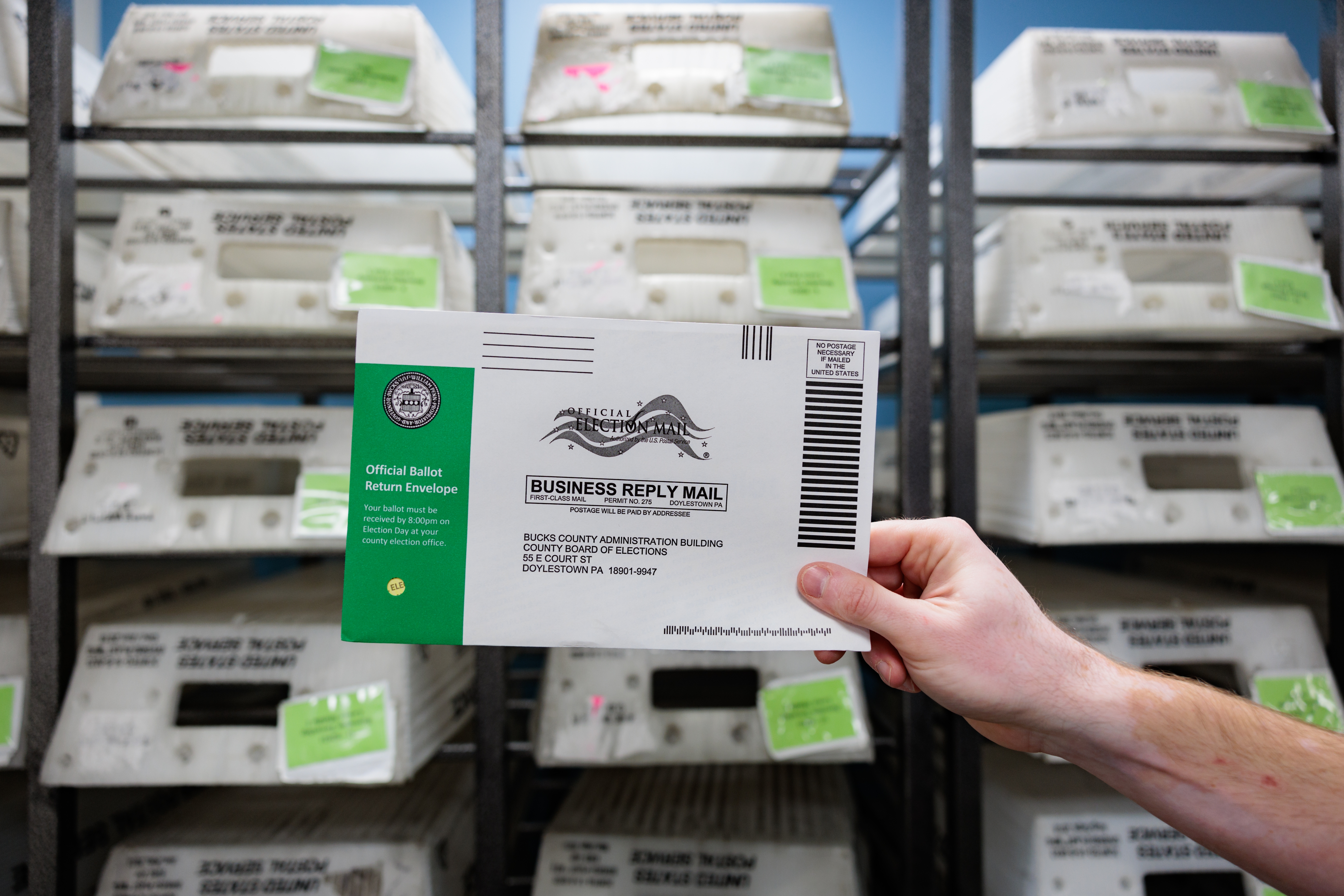 Director of the Board of Elections Tyler Burns holds a test ballot during a mail-in ballot processing demonstration on Sept. 30 in Doylestown, Pa. A fake video purporting to show ballots being destroyed in Bucks County, Pa., showed different envelopes and ballots than the county actually uses.