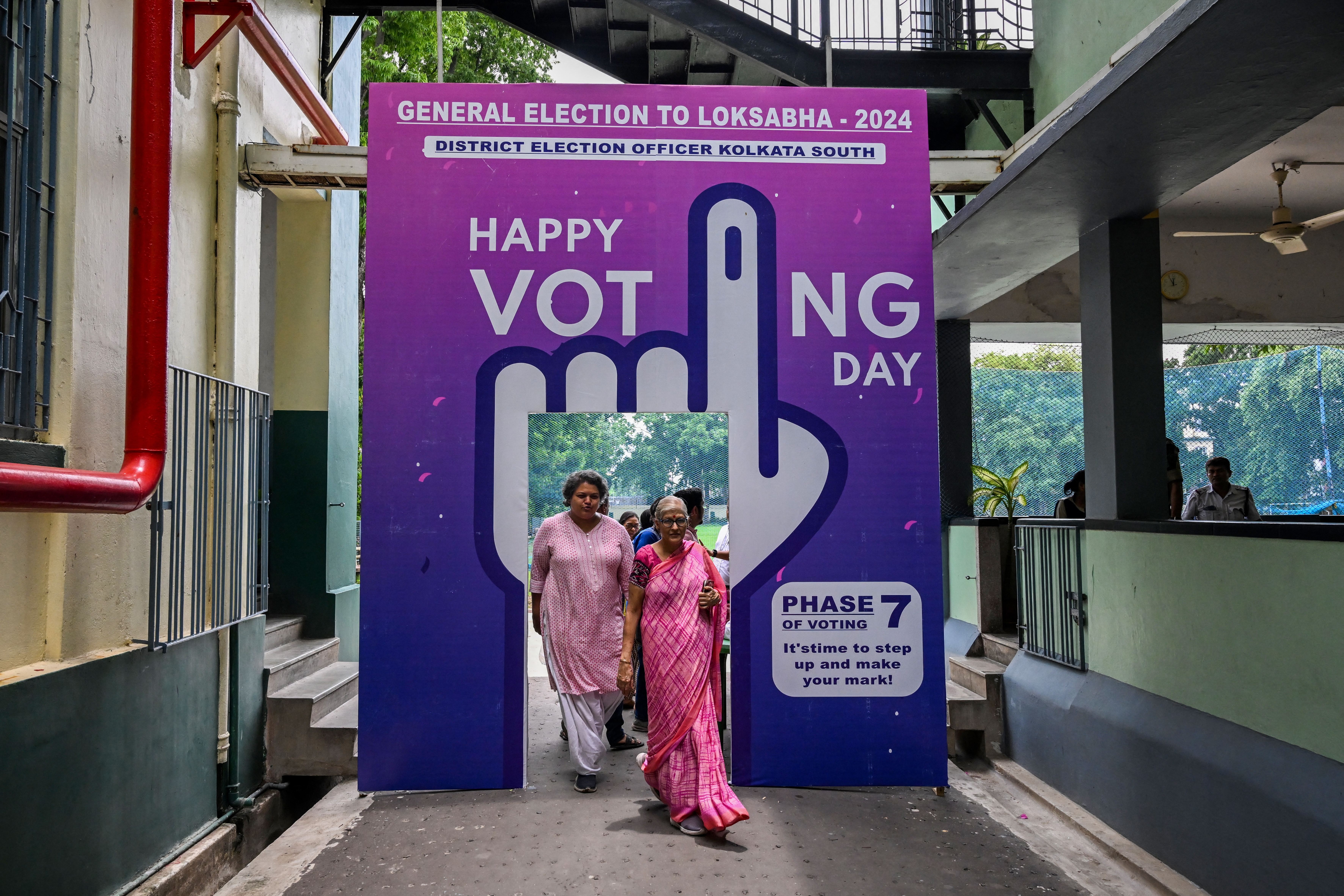 Voters leave after casting their ballot at a polling station in the final phase of voting in India