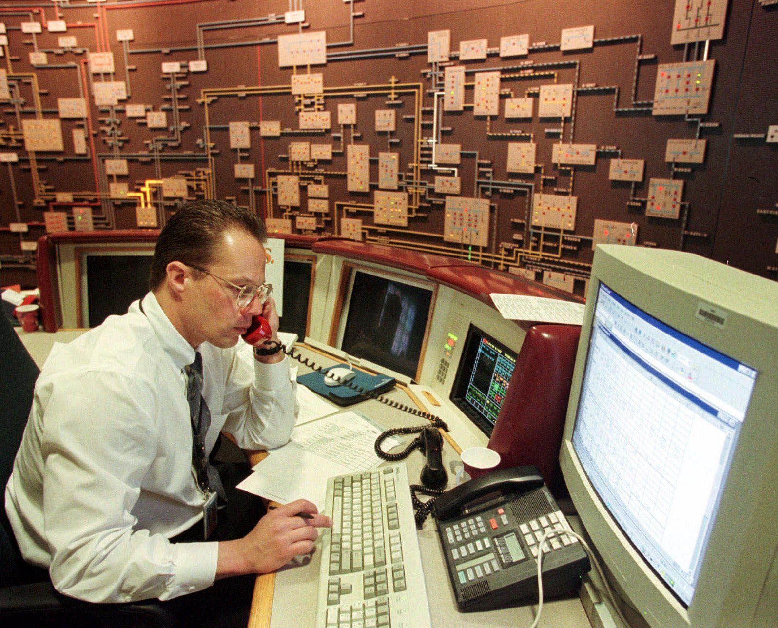 Mike Cupo, a systems operator for Public Service Electric and Gas Company, uses a special red phone to talk via radio to PSE&G staffers in the field, during a simulated Y2K drill at company headquarters in Newark, N.J., on April 9, 1999. Power plant operators across the country held drills to make sure they could keep electricity flowing if year 2000 computer glitches prevented them from communicating with each other.