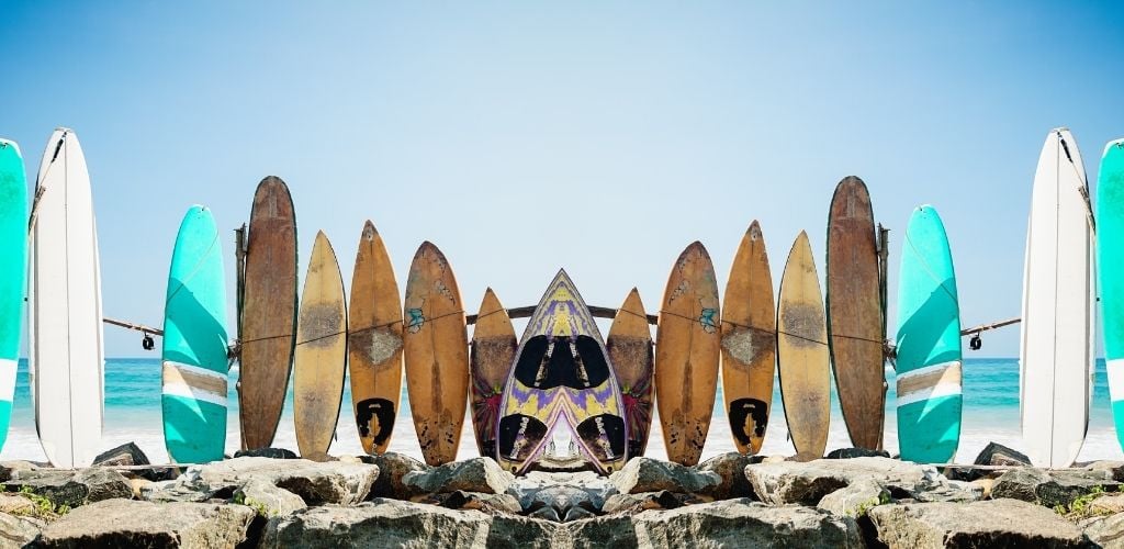 Mirror image of standing surf boards of varying size 