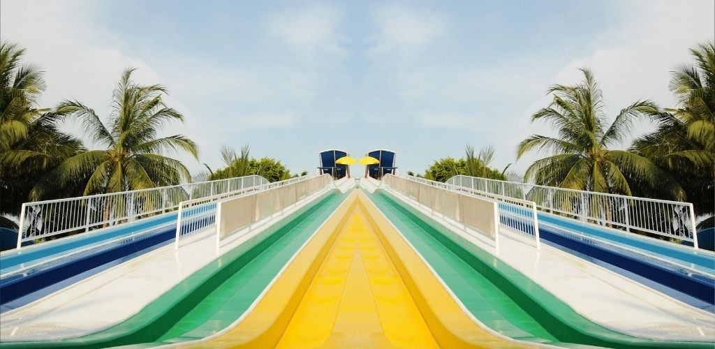 mirror image of waterpark slides, palm trees either side of slide