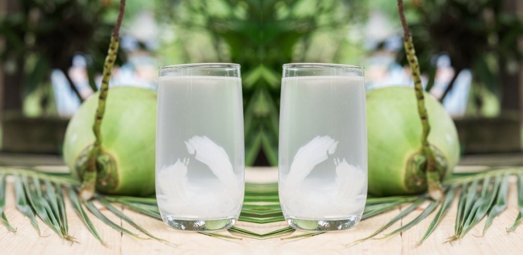 mirror image of fresh coconut water in tumbler 