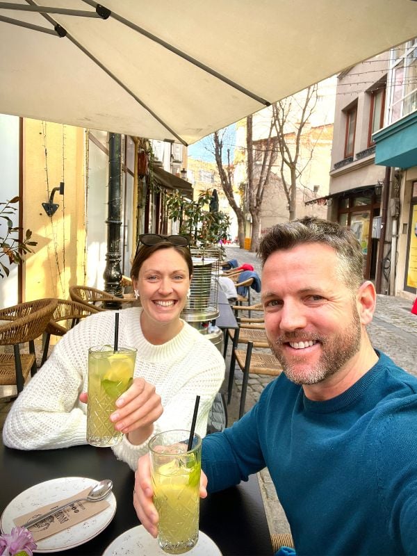 Nick & Dariece Goats On The Road enjoying some much deserved down time with drinks in an outdoor restaurant 