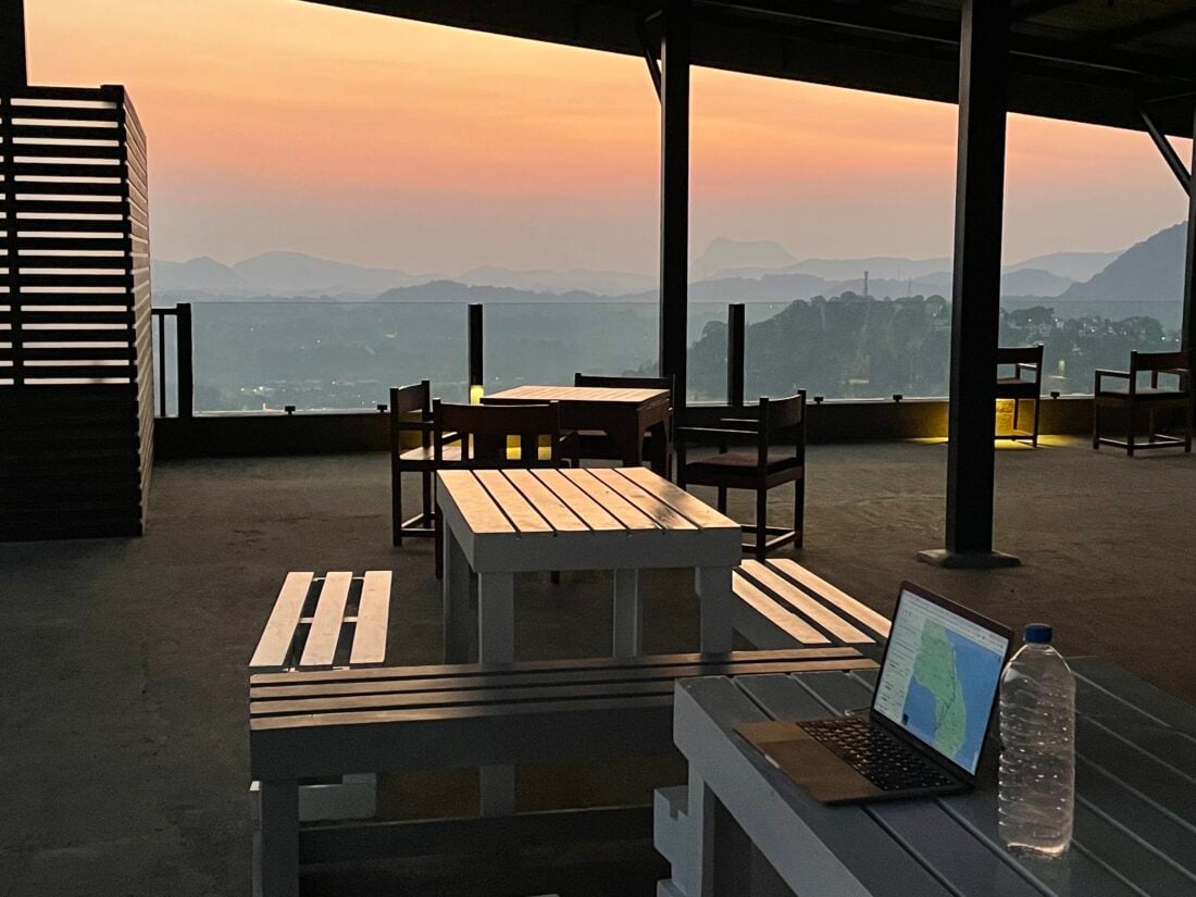 dusky, sunset skies with beautiful mountain view, outdoor table as digital nomad office, laptop on picnic bench 