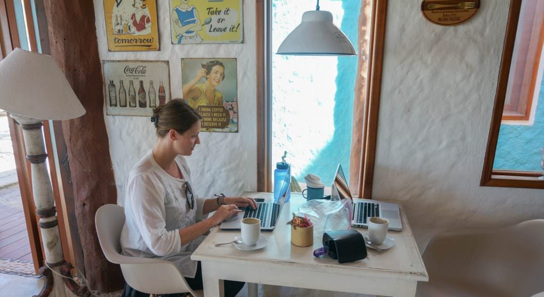 Dariece working from remote location, sat at table with laptop 