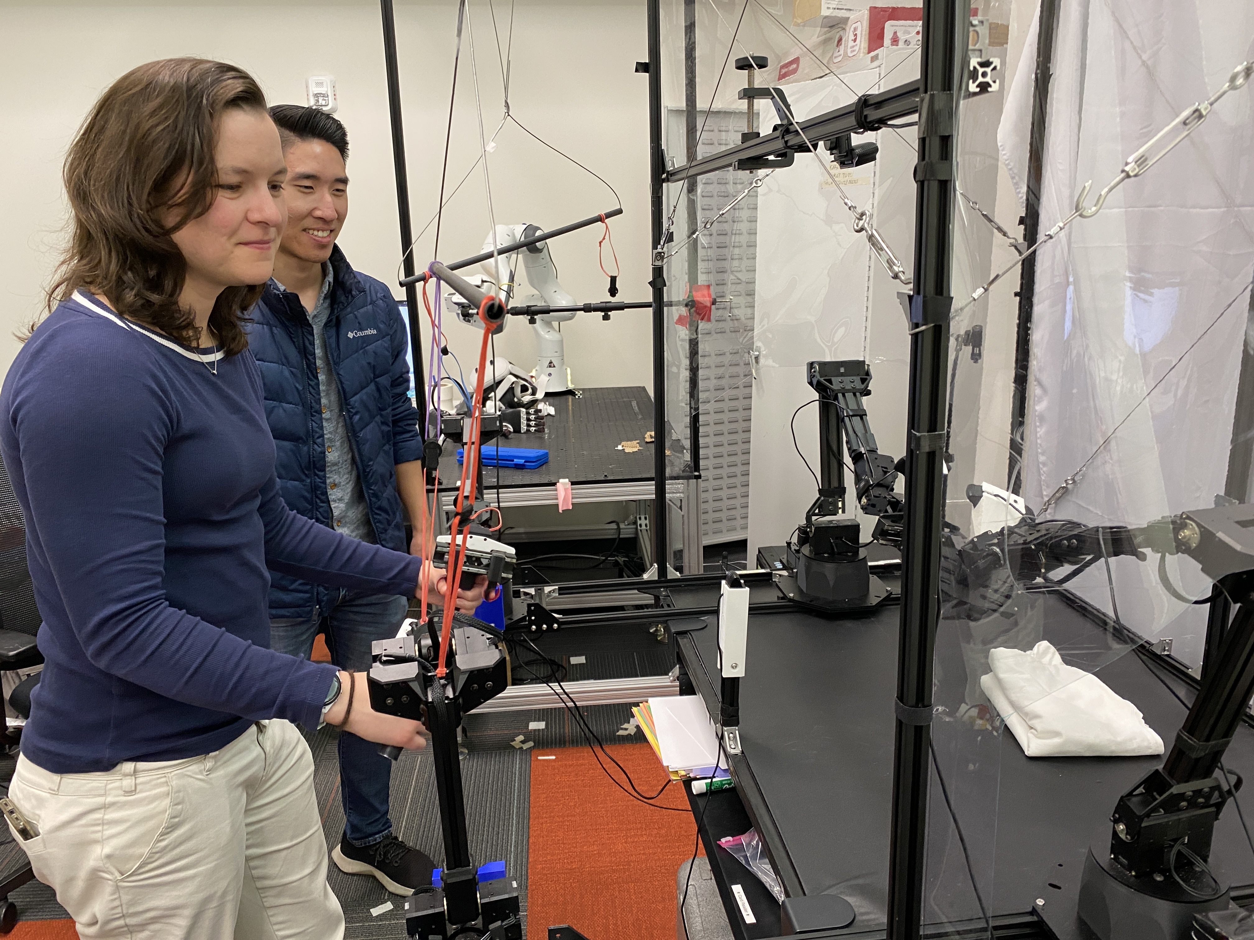 Chelsea Finn (left) and Moo Jin Kim conduct a demonstration with a robot at Stanford University.