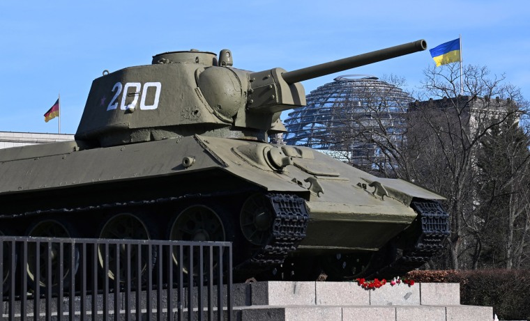 A Ukrainian flag flies over the Reichstag in Berlin behind one of the Russian T-34 tanks that are part of the Soviet War Memorial